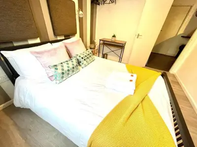 a large white bed with pillows on top of it at Serene and Cozy 1-Bedroom House with Parking in Cambridge