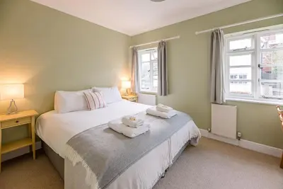 a bedroom with a bed with two towels on it at Pelican Cottage, Aldeburgh in Aldeburgh