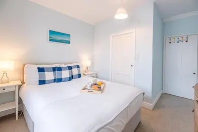 a bedroom with a white bed with a tray on it at Pelican Cottage, Aldeburgh in Aldeburgh
