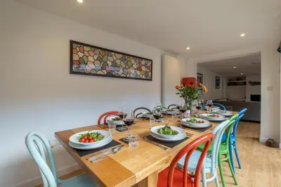 a wooden table with chairs and plates of food on it at The Pink House, Aldeburgh in Aldeburgh