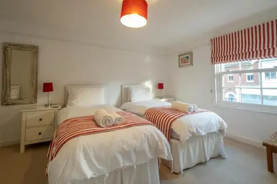two twin beds in a bedroom with a window at The Pink House, Aldeburgh in Aldeburgh