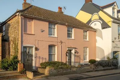 a brick house with a turret on a street at The Pink House, Aldeburgh in Aldeburgh
