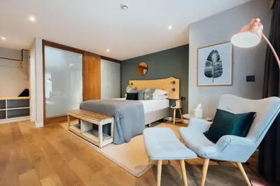 a bedroom with a bed and a chair at The Fox at Willian in Letchworth