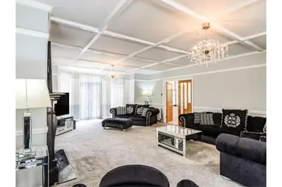 a living room with black furniture and a chandelier at 6BD Vacation Home with Indoor Pool in Canvey Island