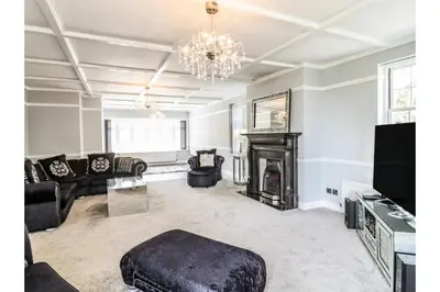a living room with a fireplace and a chandelier at 6BD Vacation Home with Indoor Pool in Canvey Island