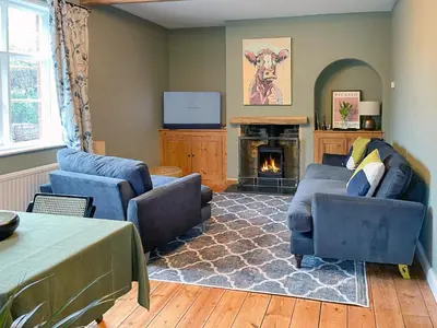 a living room with two couches and a fireplace at Corner Cottage in Alburgh