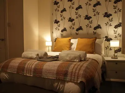 a bedroom with a bed with two towels on it at Painters at the Angel in Sudbury