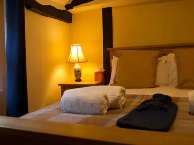 a bedroom with a bed with a lamp on a table at Painters at the Angel in Sudbury
