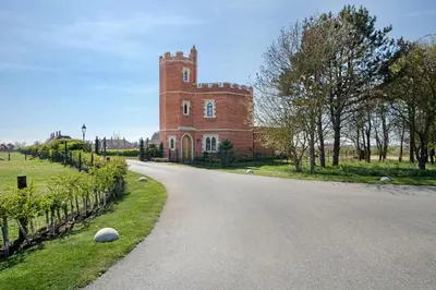 an empty road in front of a brick building at South Lodge, St Osyth Priory in Saint Osyth