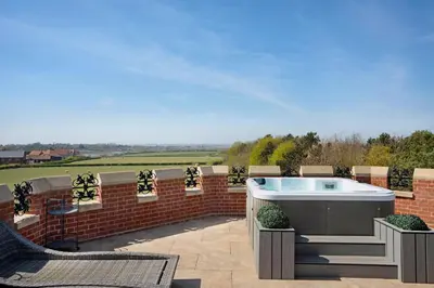 a hot tub on the patio of a house at South Lodge, St Osyth Priory in Saint Osyth