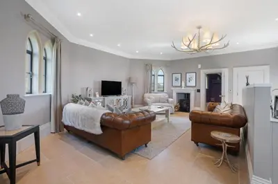 a living room with a couch and a living room with a chandelier at South Lodge, St Osyth Priory in Saint Osyth