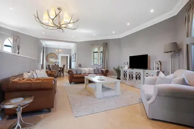 a living room filled with furniture and a chandelier at South Lodge, St Osyth Priory in Saint Osyth