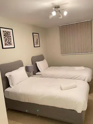 a bedroom with two beds and a window at Next-Stop Haven in Harlow