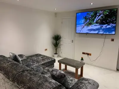 a living room with two couches and a flat screen tv at Bury St Edmunds - Apartment - Sleeps 2 - Parking in Bury Saint Edmunds
