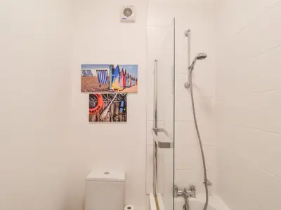 a bathroom with a toilet and a painting on the wall at Feathers, Blythburgh in Halesworth