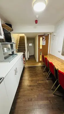 a room with a table and chairs and a staircase at White House Lodge in Cambridge
