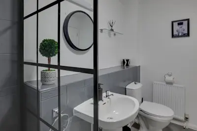 a bathroom with a sink and a toilet and a mirror at Entire home/flat perfect for contractors in Bishops Stortford