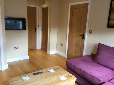 a living room with a purple couch and a table at Beautifully appointed & cosy self contained annexe in Walsham le Willows