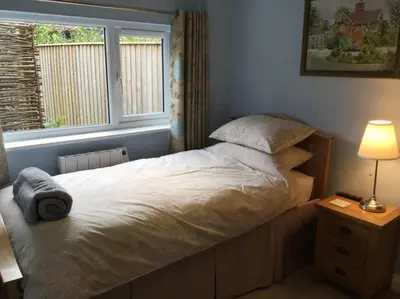 a bedroom with a large bed with a window at Beautifully appointed & cosy self contained annexe in Walsham le Willows