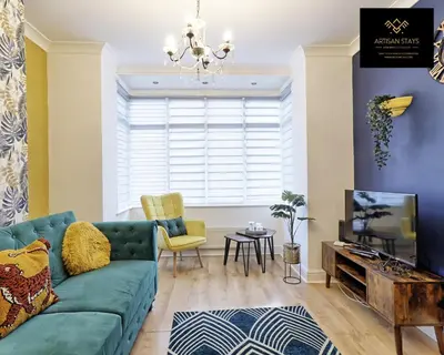 a living room with a green couch and a tv at Spacious 3 Bedroom and 2 Bathroom in Southend-on-Sea By Artisan Stays I Weekly or Monthly Stay Offer I Free Parking I Sleeps 7 in Southend-on-Sea