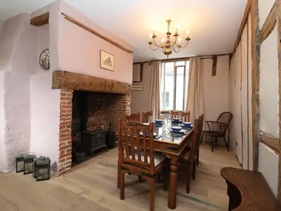 a dining room with a table and a fireplace at The Bridewell in Woodbridge