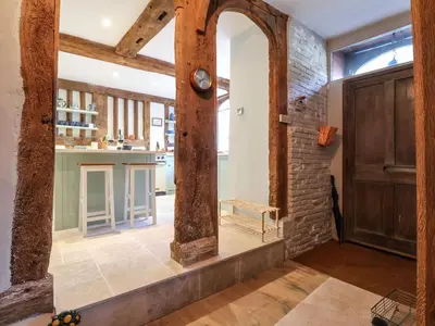 a hallway with a large wooden door and a brick wall at The Bridewell in Woodbridge