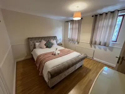 a bedroom with a bed with a stuffed animal on it at Super King Bed Suite, Executive office, fast WiFi, free parking in St Ives