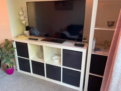 a large flat screen tv on a white entertainment center at St Ives, King Bed Cosy home, parking, fast Wi Fi in St Ives