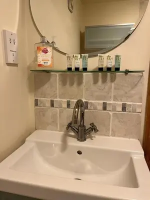 a sink in a bathroom with a mirror and a mirror at Two Storey Annex in Cottenham