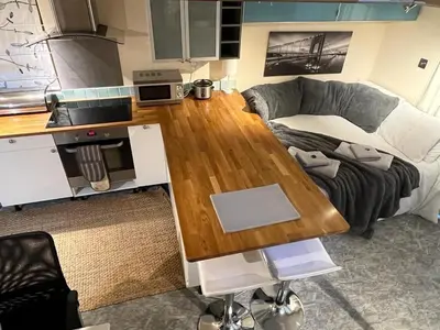 a living room with a couch and a wooden table at Studio Annex in Cottenham