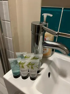 a bathroom sink with four cups of moisturizers on it at Studio Annex in Cottenham