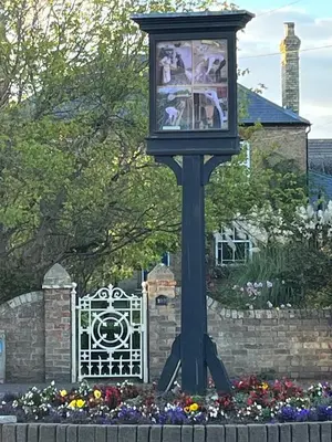 a clock on top of a pole in a garden at Studio Annex in Cottenham