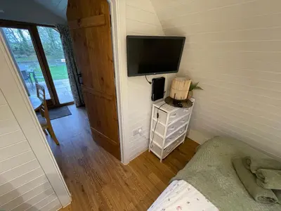 a small room with a television on a wall at Wimbish Hall Cabins in Wimbish