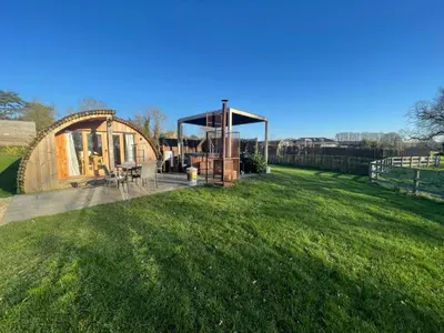a large yard with a gazebo and a house at Wimbish Hall Cabins in Wimbish