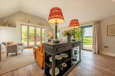 a living room with a table and a couch at Elegant luxurious cottage - The Dove House in Ipswich
