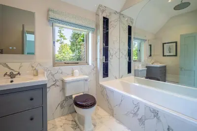 a bathroom with a tub and a toilet and a sink at Elegant luxurious cottage - The Dove House in Ipswich