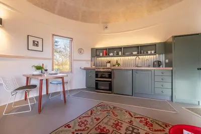 a kitchen with blue cabinets and a table in a room at Extraordinarily converted grain stores - The Silos in Ipswich