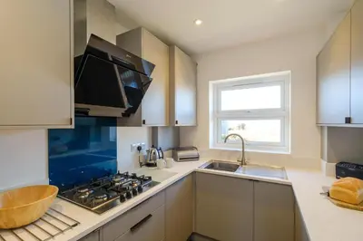 a kitchen with a sink and a stove top oven at Admiral's Rest in Aldeburgh