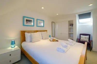 a bedroom with a large white bed with towels on it at Admiral's Rest in Aldeburgh