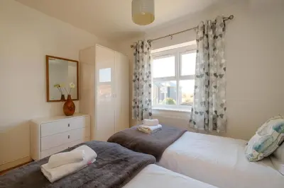 a bedroom with two beds and a window at Admiral's Rest in Aldeburgh