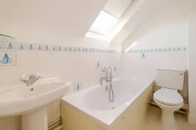 a bathroom with a sink and a tub and a toilet at Admiral's Rest in Aldeburgh