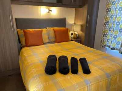 a bed with two pairs of black socks on it at VaLa VistA - Holiday Home On The Beach in Jaywick Sands