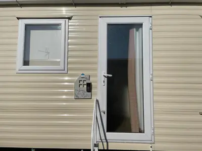 a house with a door and two windows on it at VaLa VistA - Holiday Home On The Beach in Jaywick Sands