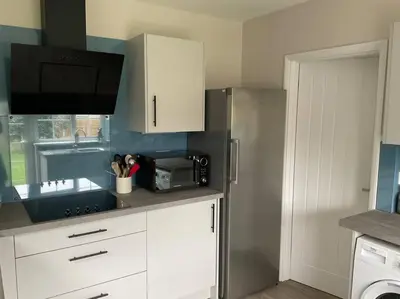 a kitchen with white cabinets and a microwave at Klara's House in West Mersea
