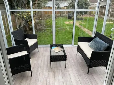 a screened in porch with chairs and a coffee table at Klara's House in West Mersea