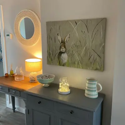 a table with a painting of a rabbit on the wall at Klara's House in West Mersea