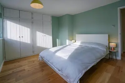 a bedroom with a large bed with white cabinets at Unique 5BD Farm House Perfect for Relaxing in Ipswich