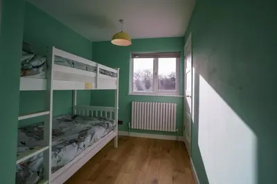a green room with two bunk beds and a window at Unique 5BD Farm House Perfect for Relaxing in Ipswich