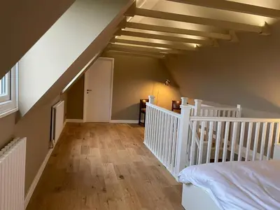 an attic room with a staircase and a bed at Unique 5BD Farm House Perfect for Relaxing in Ipswich