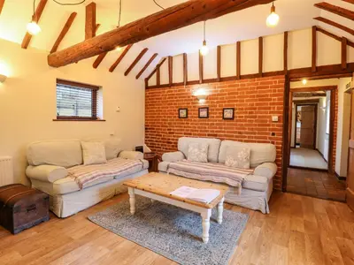 a living room with two couches and a brick wall at The Granary in Colchester